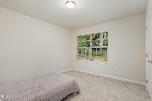 unfurnished bedroom featuring baseboards and light colored carpet