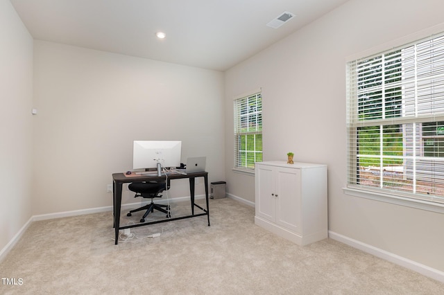 home office featuring light colored carpet, plenty of natural light, and baseboards