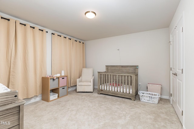 bedroom with a nursery area and carpet flooring