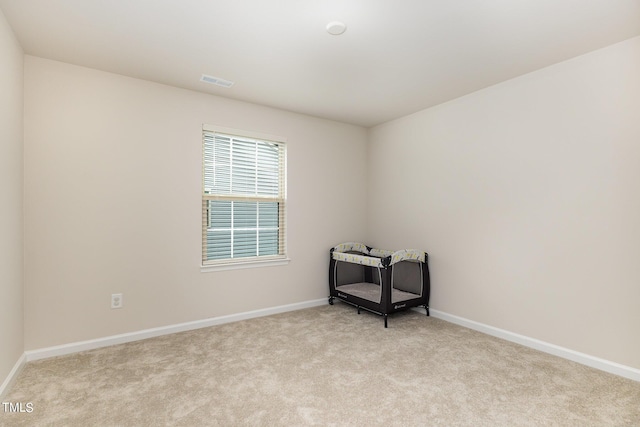 carpeted spare room with visible vents and baseboards