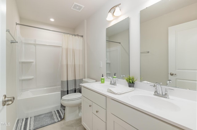 full bathroom with toilet, double vanity, a sink, and visible vents