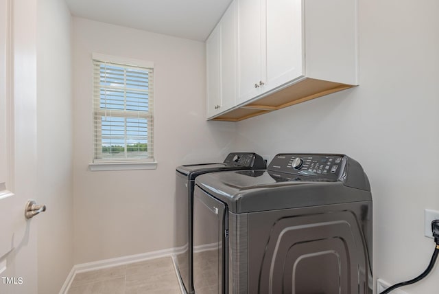 washroom with light tile patterned floors, independent washer and dryer, cabinet space, and baseboards