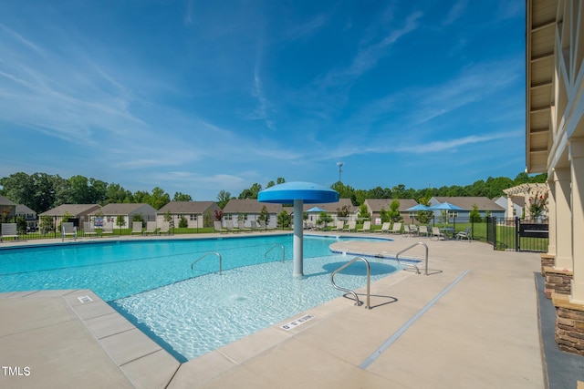 pool featuring a residential view, a patio area, and fence