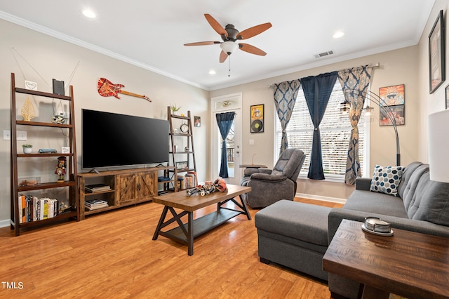 living room featuring light hardwood / wood-style floors, crown molding, and ceiling fan