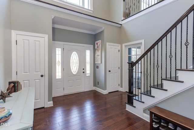 foyer entrance featuring a high ceiling, dark hardwood / wood-style floors, and crown molding