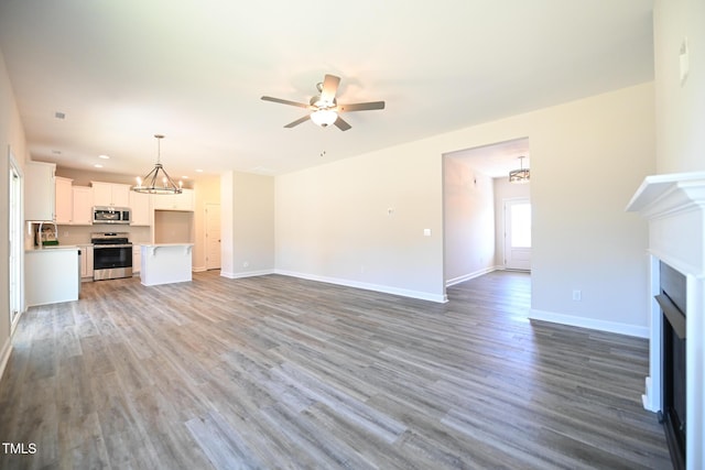 unfurnished living room with hardwood / wood-style flooring and ceiling fan