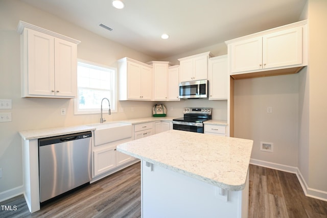 kitchen featuring sink, a kitchen island, white cabinets, and appliances with stainless steel finishes