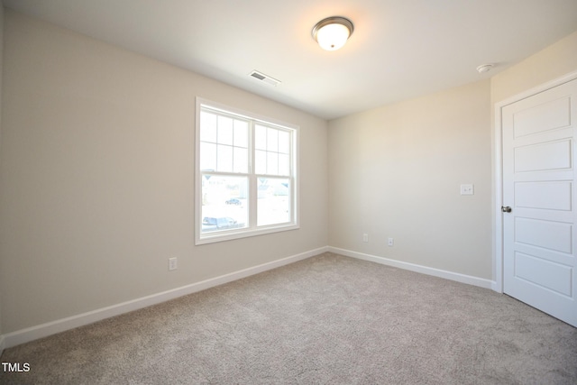 spare room featuring light carpet