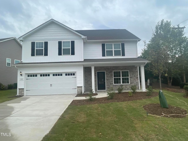 view of front of property featuring a garage, a front lawn, and covered porch