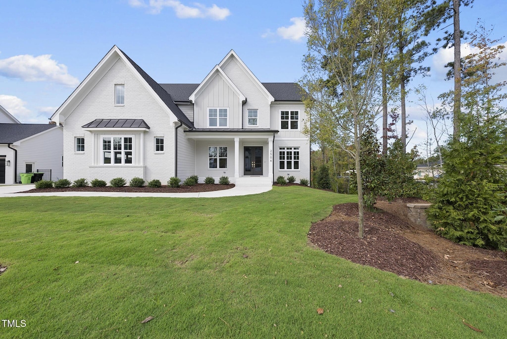 2506 Silas Peak Ln, Apex, NC 27523 - modern farmhouse style home with a standing seam roof, a front lawn, metal roof, and board and batten siding