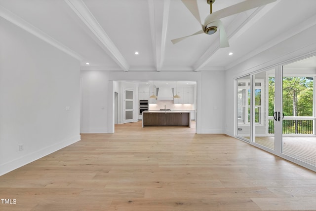 unfurnished living room with sink, light hardwood / wood-style flooring, crown molding, and beam ceiling