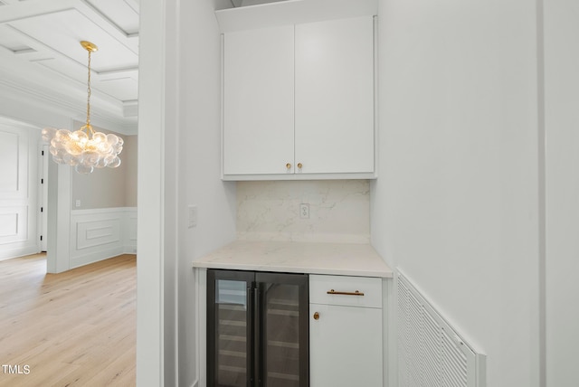 bar featuring white cabinets, wine cooler, hanging light fixtures, light hardwood / wood-style flooring, and decorative backsplash