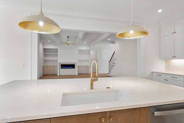 kitchen with dishwasher, beamed ceiling, hanging light fixtures, and white cabinets