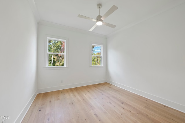 spare room featuring ornamental molding, plenty of natural light, and light hardwood / wood-style floors