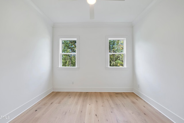 spare room featuring plenty of natural light, crown molding, and light hardwood / wood-style flooring