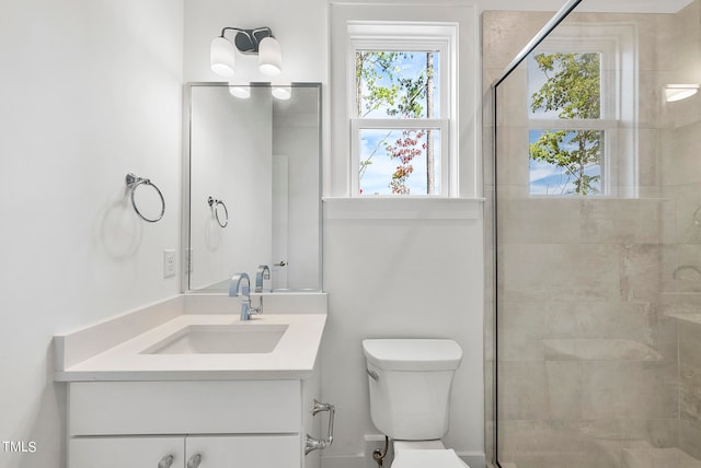 bathroom with an enclosed shower, vanity, and toilet