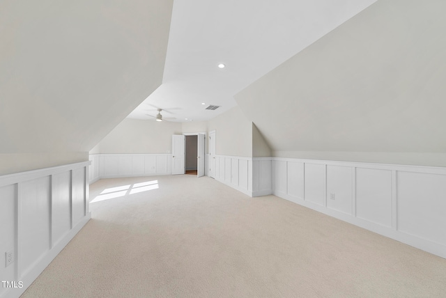 additional living space with light carpet, ceiling fan, and vaulted ceiling