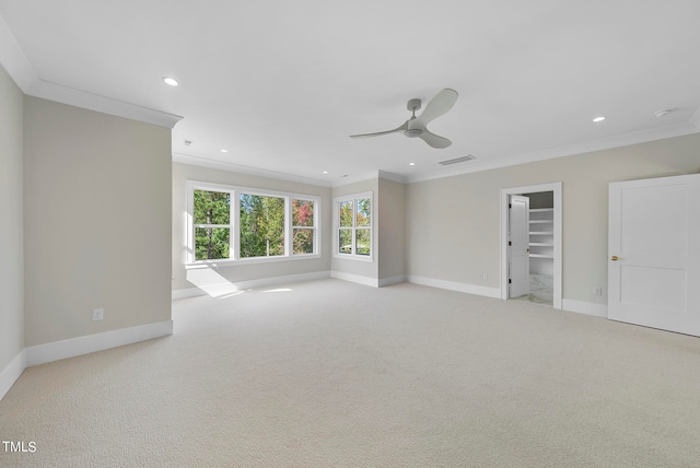 spare room featuring light carpet, crown molding, and ceiling fan