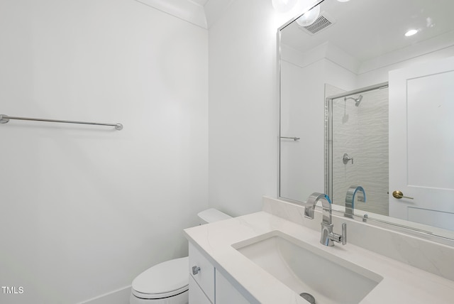 bathroom with vanity, a shower with door, and toilet