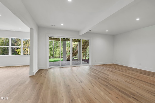 interior space with light hardwood / wood-style floors and beamed ceiling