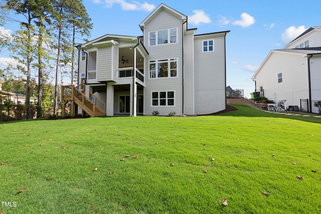 rear view of property featuring a yard and ceiling fan