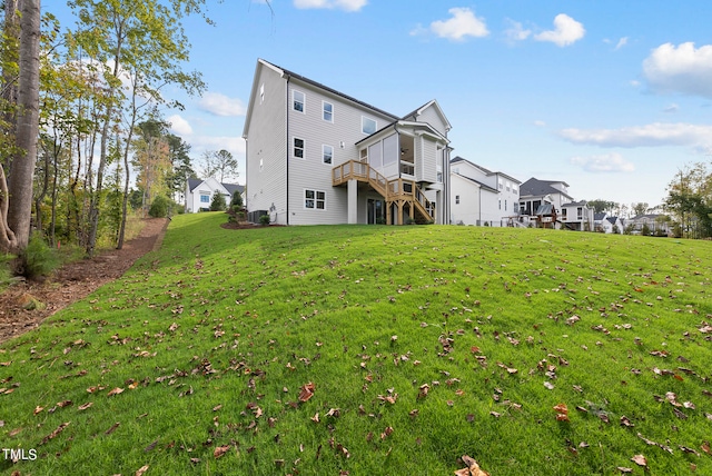 back of property with a wooden deck and a lawn