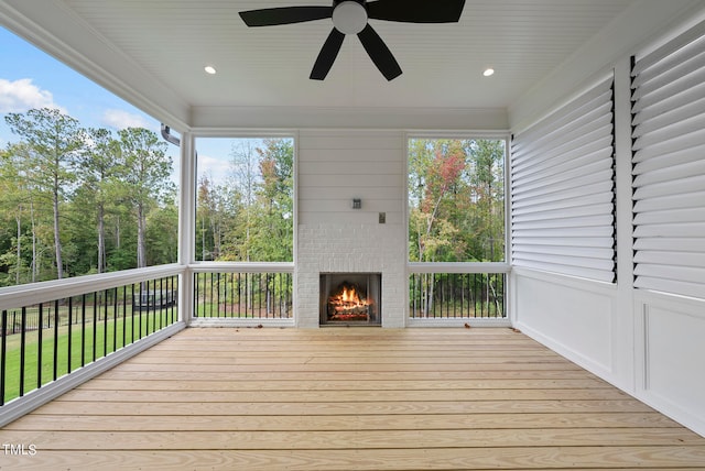 deck featuring an outdoor brick fireplace and ceiling fan