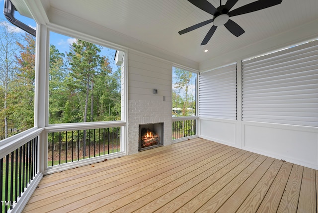 unfurnished sunroom featuring ceiling fan and a wealth of natural light