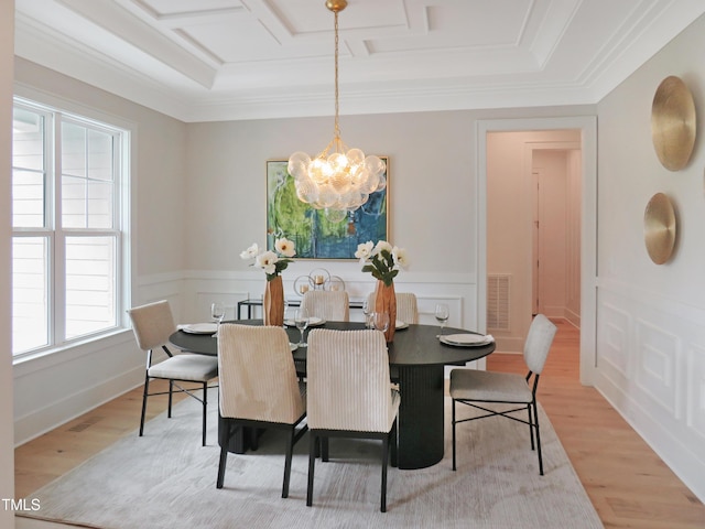 2506 Silas Peak Ln, Apex, NC 27523 - dining space featuring light wood-style flooring, a chandelier, coffered ceiling, ornamental molding, and a wainscoted wall
