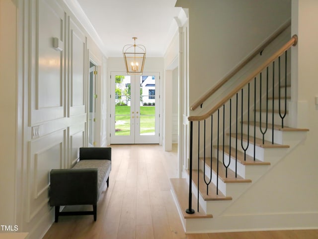2506 Silas Peak Ln, Apex, NC 27523 - foyer entrance featuring a chandelier, stairs, wood finished floors, french doors, and ornamental molding