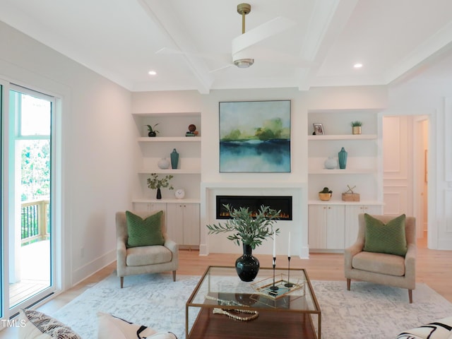 2506 Silas Peak Ln, Apex, NC 27523 - living area featuring built in features, beamed ceiling, light wood-style floors, a lit fireplace, and recessed lighting