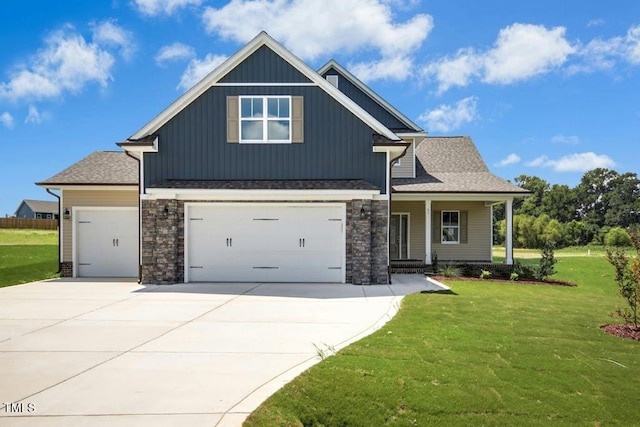 view of front of property with a garage, a porch, and a front lawn