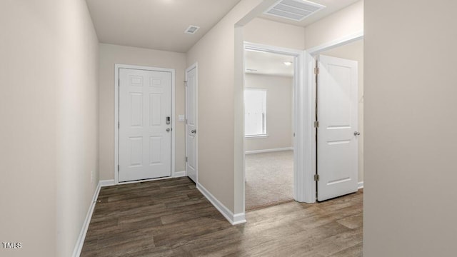 interior space with visible vents, baseboards, and wood finished floors