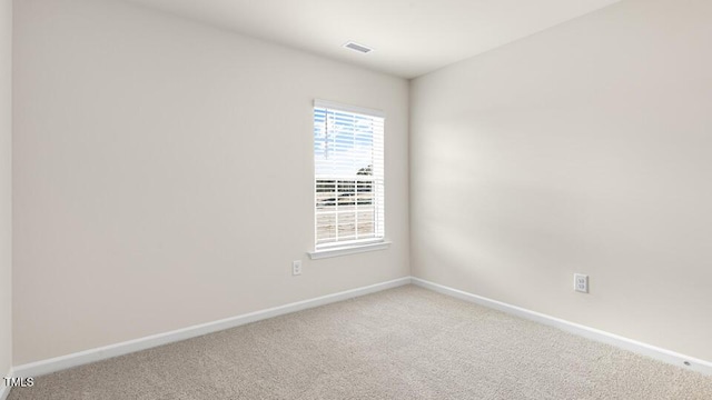 spare room with visible vents, baseboards, and carpet flooring