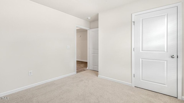 unfurnished bedroom with carpet flooring and baseboards