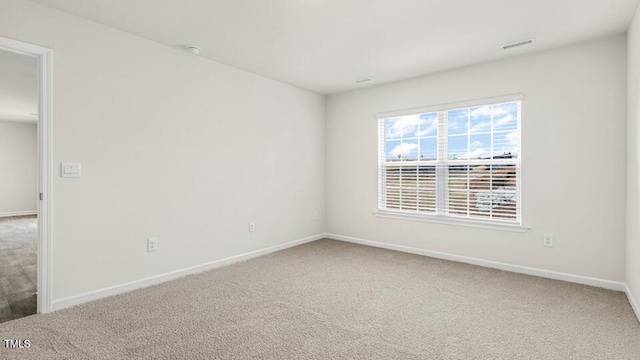 unfurnished room featuring visible vents, carpet floors, and baseboards