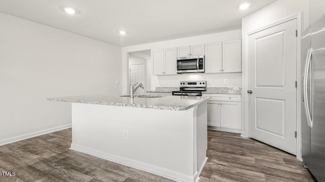 kitchen featuring a sink, an island with sink, dark wood finished floors, and stainless steel appliances