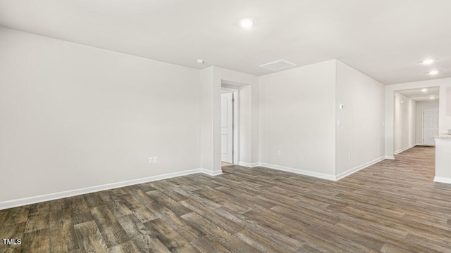 unfurnished room with dark wood-type flooring, recessed lighting, visible vents, and baseboards