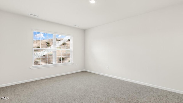 carpeted empty room with visible vents and baseboards