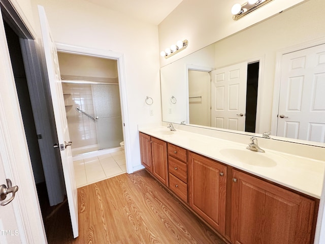 4712 Fox Fern Ln, Raleigh, NC 27604 - bathroom with double vanity, a shower with door, toilet, and wood finished floors