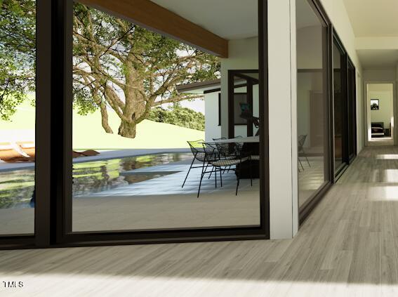 doorway to outside featuring beamed ceiling and light hardwood / wood-style flooring