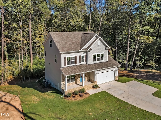 traditional-style house featuring covered porch, roof with shingles, a garage, and driveway