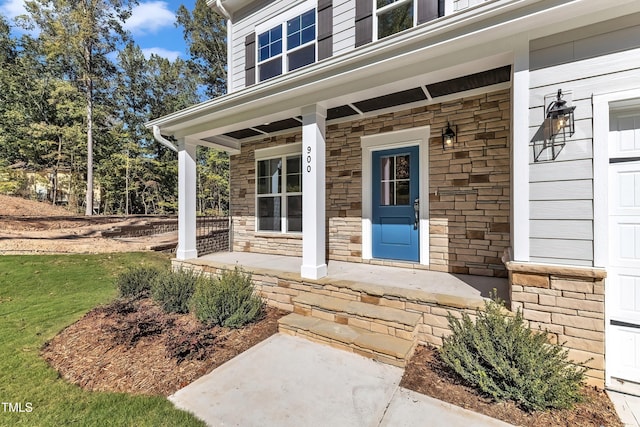 view of exterior entry featuring a porch and a garage