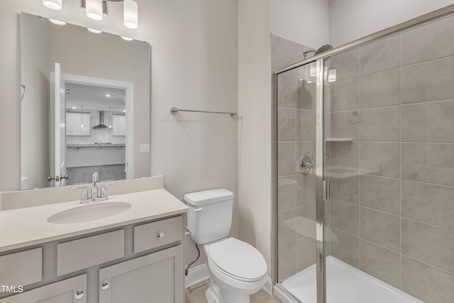 bathroom featuring a shower stall, vanity, and toilet