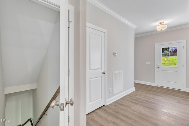 entrance foyer featuring crown molding and light wood-type flooring