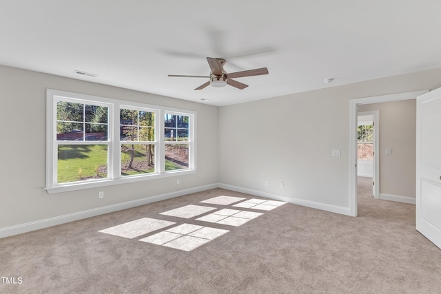 spare room featuring ceiling fan, a healthy amount of sunlight, and light colored carpet