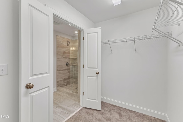 walk in closet featuring light colored carpet