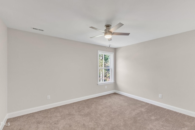 carpeted spare room featuring ceiling fan