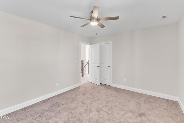spare room with carpet flooring, baseboards, a ceiling fan, and visible vents