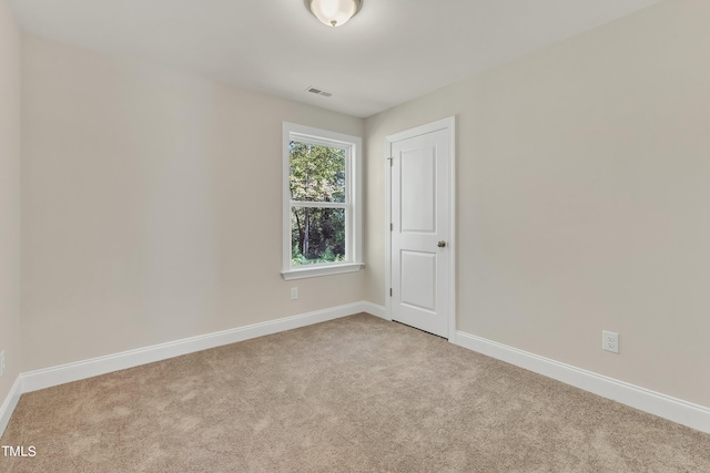 carpeted spare room featuring baseboards and visible vents